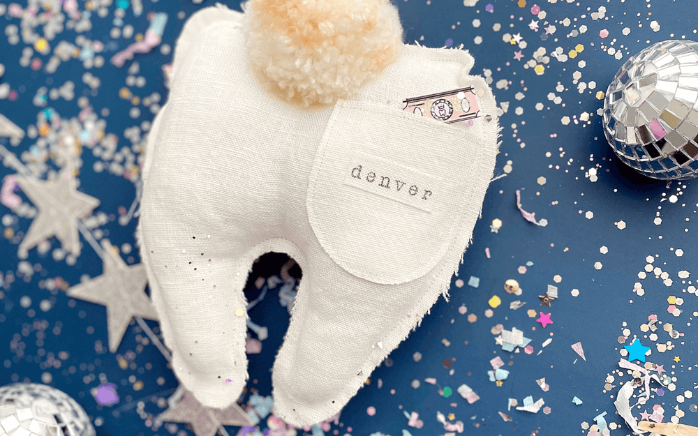Article answering what does the tooth fairy do with teeth. The picture shows a personalized tooth fairy pillow with pocket and confetti.
