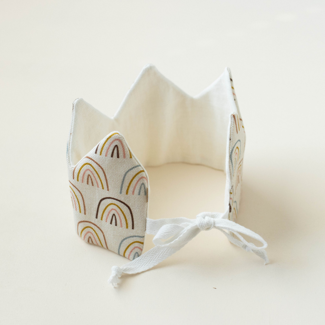Baby birthday crown with rainbow pattern on a white background