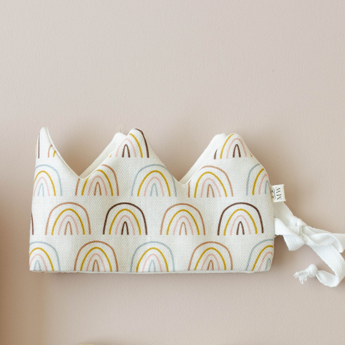 Fabric crown with rainbow pattern on a beige background