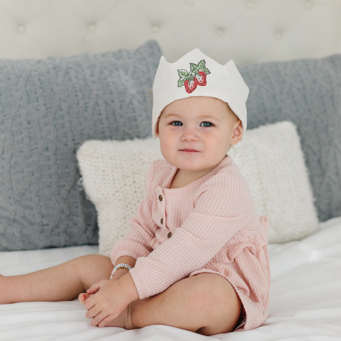 baby girl wearing a linen crown with strawberries embroidered on it