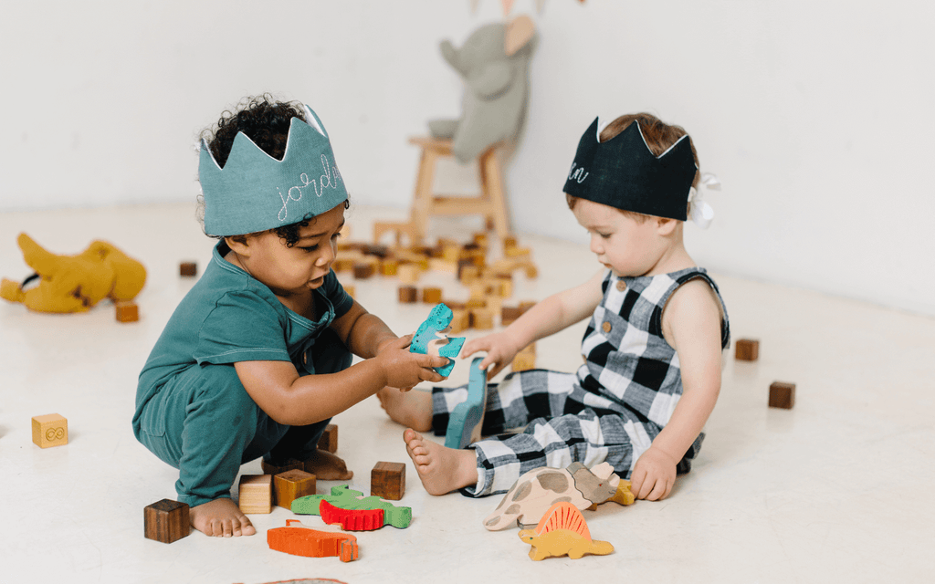 first birthday party game ideas for toddlers and kids playing with blocks wearing birthday party crowns