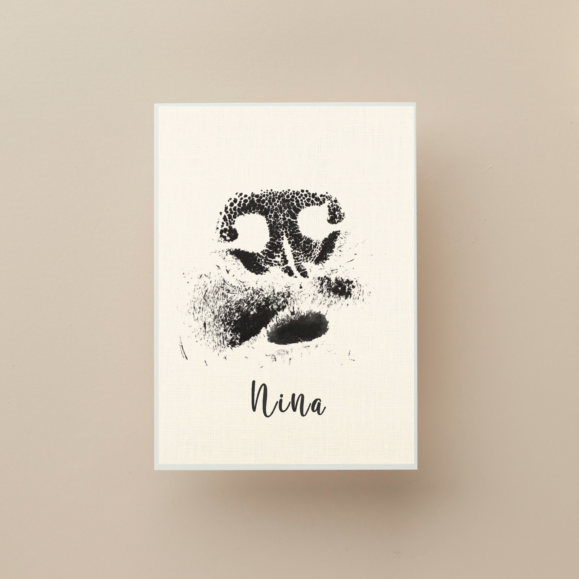 Framed artwork of a dog nose print with the name 'Nina' on a beige background