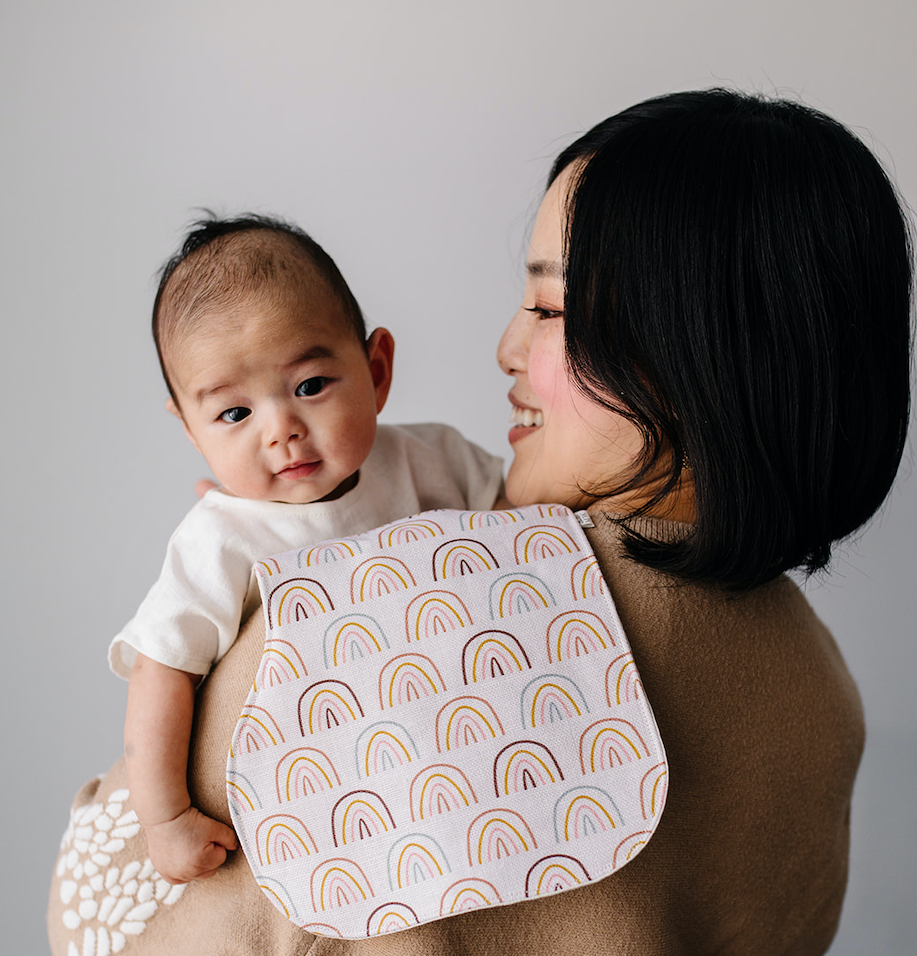 Mom holding newborn baby over her shoulder.