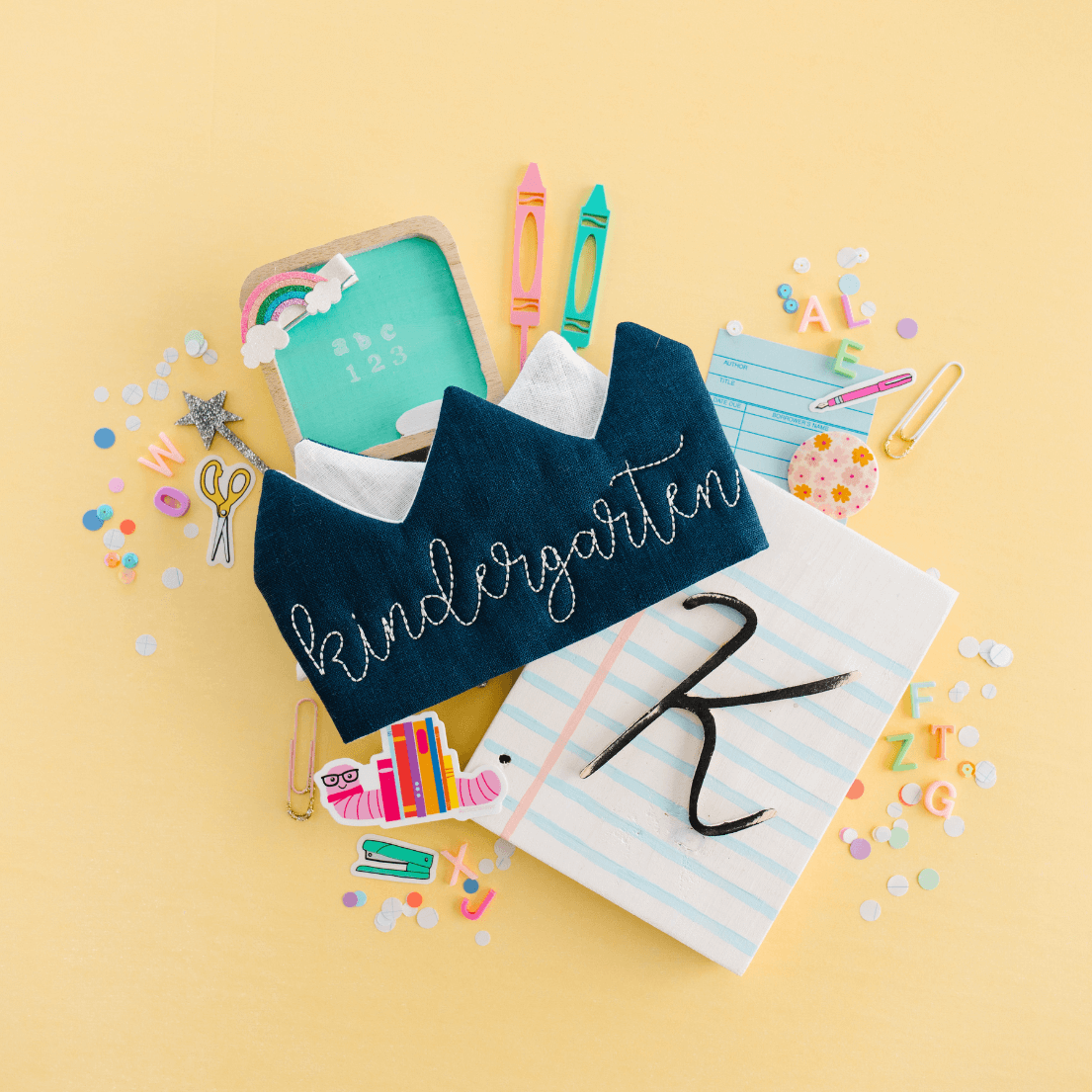 Kindergarten first day of school crown displayed with colorful school supplies, personalized back to school photo prop
