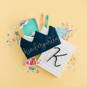 Kindergarten first day of school crown displayed with colorful school supplies, personalized back to school photo prop