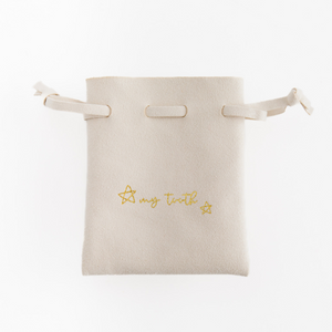 cream suede drawstring tooth fairy pouch with my tooth on the front from Madly Wish
