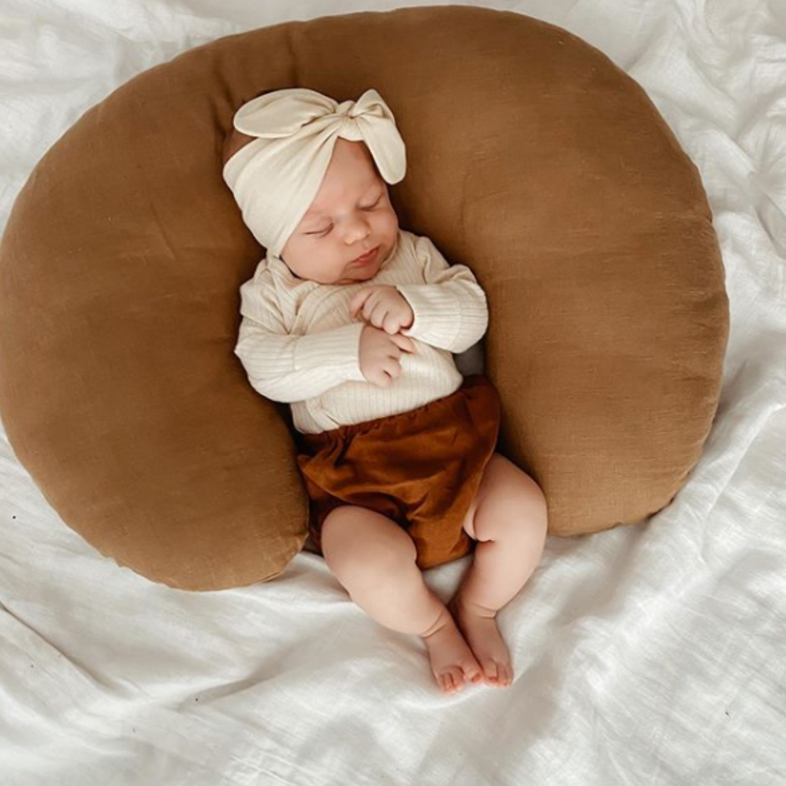 baby girl laying on rust linen nursing pillow slipcover for boppy pillow