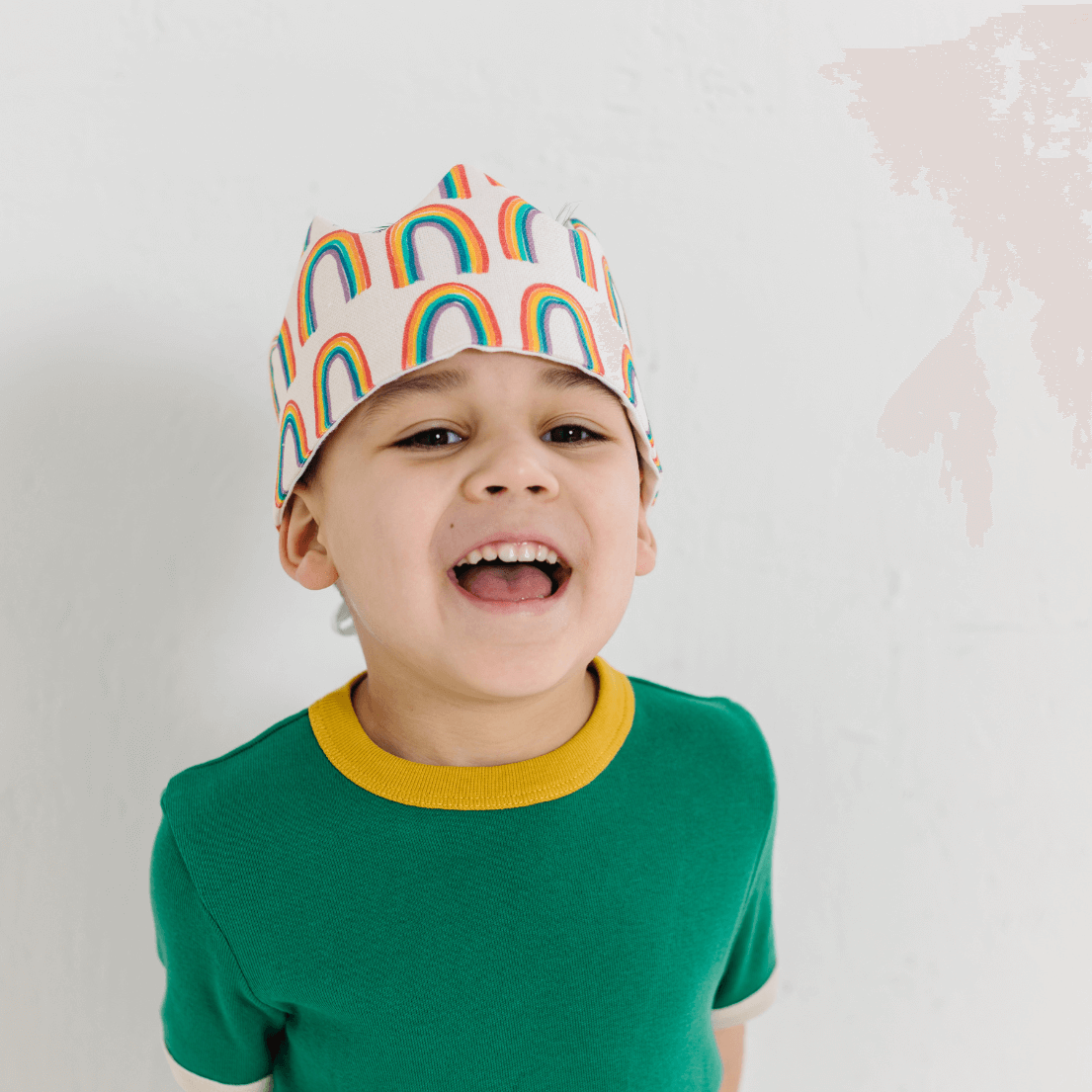 BOY PLAYING AND WEARING A RAINBOW HEADBAND