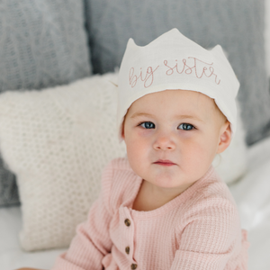 little girl wearing a big sister crown