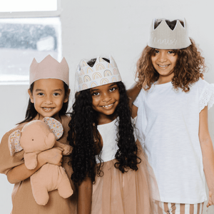 three girls wearing birthday crowns