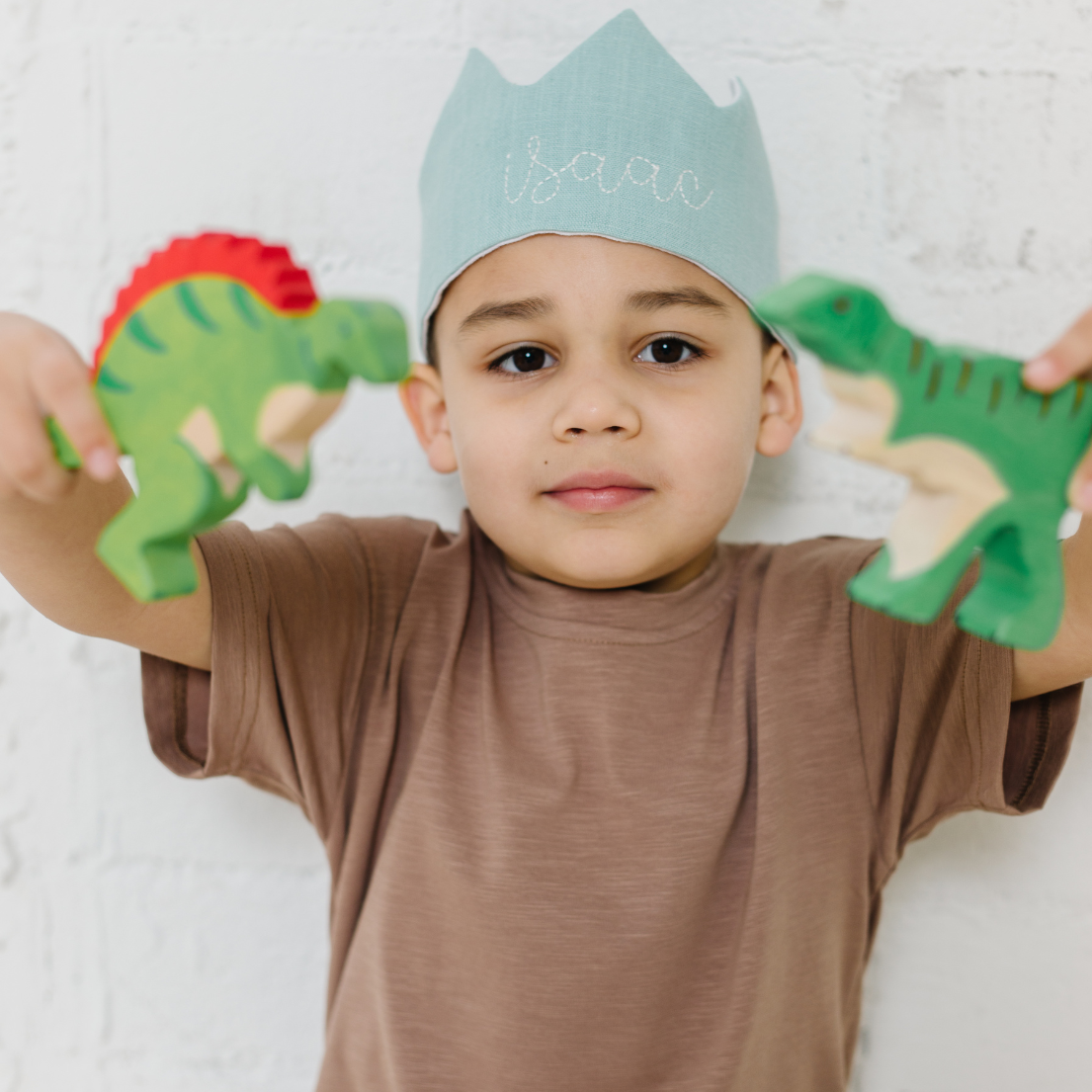 child playing with toys wearing a blue birthday hat