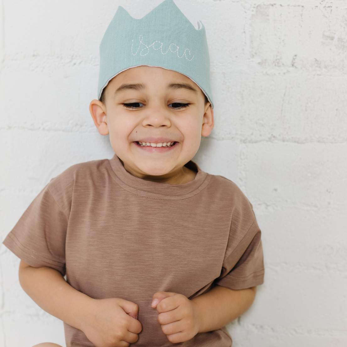 little boy wearing personalized light blue linen crown