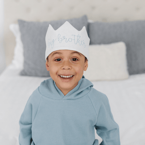 little boy wearing a big brother crown