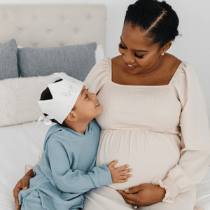 boy sitting with pregnant mom wearing a crown